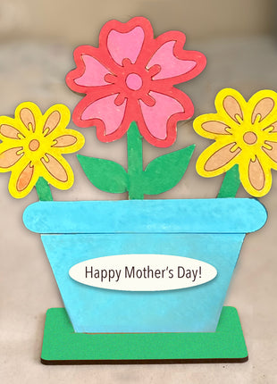 Wooden shelf sitter flower pot with three colorful flowers. 